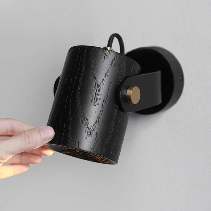 Umea directional wall spotlight beside a double-height feature wall